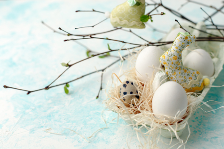 Easter scene with spring fresh greenery branches, rabbit and box of eggs, springtime festive backgroundの写真素材