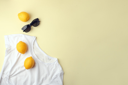 White shirt, sunglasses and lemons on yellowの写真素材