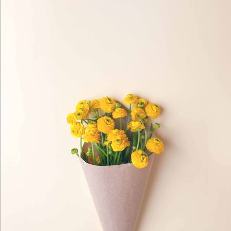 Yellow flower in craft paper package, minimal springtime summerの写真素材