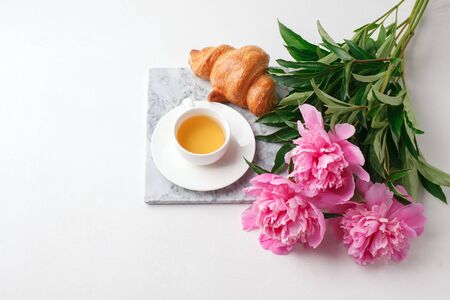 Breakfast for Valentines day with cup of tea, croissant, flowers on white table from above in flat lay style, seasonal springtime holiday background, blogger lifestyleの写真素材