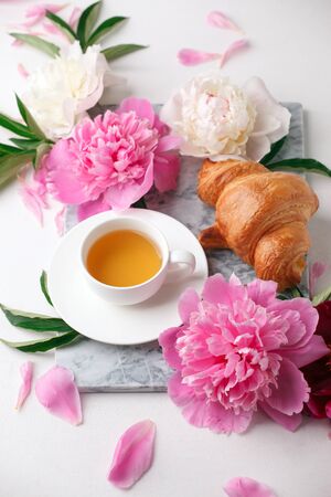 Beautiful still life with tea cup and peonies.Top view, summer french breakfast of bloger, feminine holiday morning conceptの写真素材