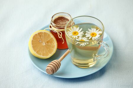 Chamomile flowers and chamomile tea. Chamomile tea in glass teacup with flowers, honey and lemon, top view, prevention of seasona flu coldsの写真素材