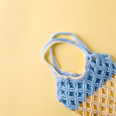 top view of empty yellow blue string bag on yellow background, zero waste eco-friendly trendy shopping minimal conceptの写真素材