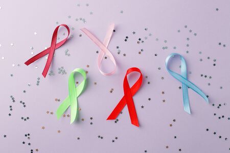 Different colorful ribbons on white wooden background. Cancer concept