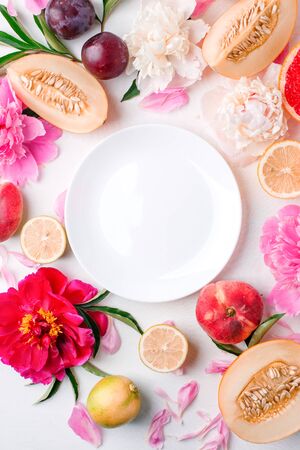 Cafe menu background with beautiful peonies flowers fruits and white plate, seasonal spring summer time concept, freshness, detox creative flat lay, stylish elegance compositionの写真素材