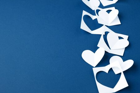 Valentine background with white blue paper craft hearts border on classic blue background, Happy lovers day card mockup, copy space, winter february romance conceptの写真素材
