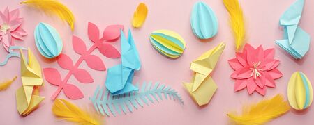Easter holiday creative background with papercraft eggs, flowers, origami bunny on coral pink...