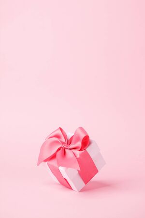 White gift box and on pink background with copy space for text. Luxury fashion, shopping sale concept. wedding, marriage or birthday composition. Coupon, flyer conceptの写真素材