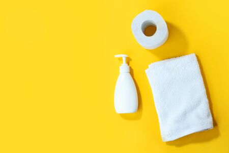Toilet paper roll, sanitizer antiseptic gel liquid soap on yellow background. People are stocking up essentials for home quarantine. Consumer buying panic about coronavirus covid-19 concept, hygieneの写真素材