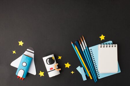 Rocket cut from paper toilet roll tube and school tools set on blackの写真素材