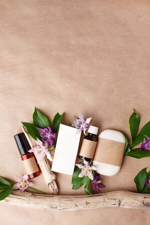 Herbal natural facial cosmetic products set with herbs and flowers on paper craft background, top view. Branding mock up, sustainable packaging, eco-friendly wellness products, self-care focusの写真素材