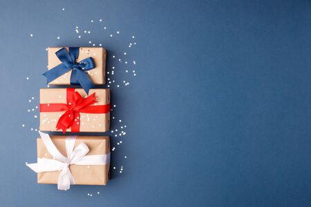 Red, blue and white gift boxes on classic blue background in the national colors of America, Russia,...