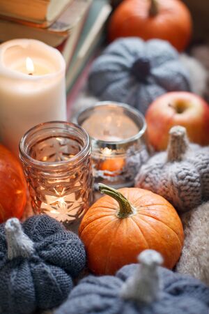 AUTUMN MOOD Seasonal fall comfy cozy background, happy thanksgiving holiday, Candle pumpkin and handcrafted knitting decor on window, warm moody tranquil conceptの写真素材