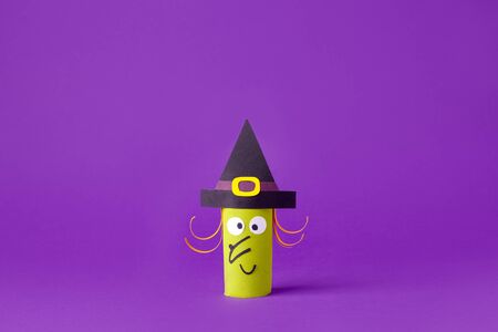 Halloween witch on purple for Halloween concept background. Paper crafts, easy DIY. Handcraft creative idea from toilet tube for daycare, kindergarten, recycle concept, copy spaceの写真素材