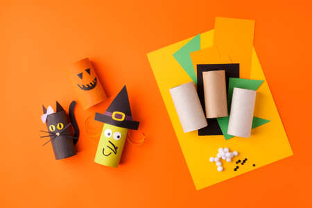 Child creates decorations for Halloween party from toilet roll. Easy eco-friendly DIY master class, craft for kids. Materials for creativity, recycle reuse concept of holiday art activitiesの写真素材
