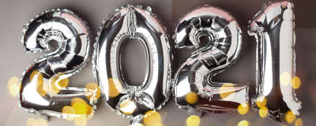 Happy New year 2021 celebration. Silver foil balloons numeral 2021 on gray background. Flat lay,...