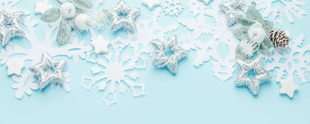 Christmas decoration on the pastel blue background. Paper snowflakes and silver stars. New year...