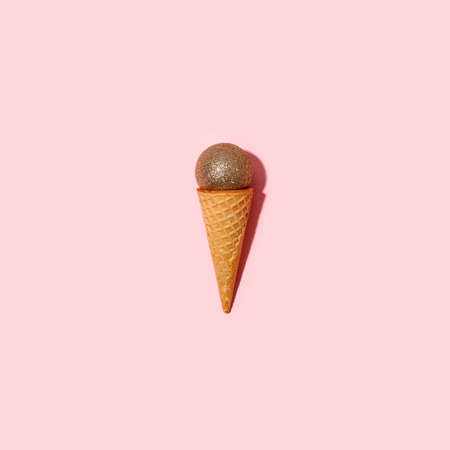 Christmas decoration bauble in ice cream cone. New Year minimal concept, hard shadow, flyer, coupon,...