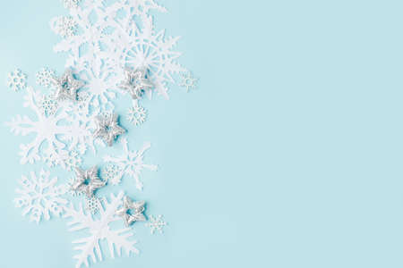 Winter pattern made of papercraft snowflakes on blue background. Winter concept. Flat lay. Tender...