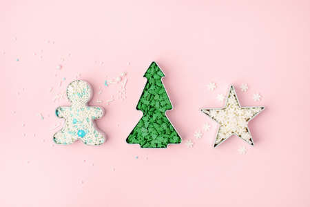 Christmas man, star, tree shape for cookies and multicolored sweet decorations on a light pink...