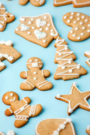 Happy New Year's set of gingerbread cookies and man in face mask from ginger biscuits glazed sugar icing decoration on blue background, minimal seasonal pandemic winter holiday cardの写真素材