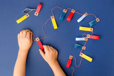 Making of handmade christmas garland from colorful paper with your own hands. Children's DIY...