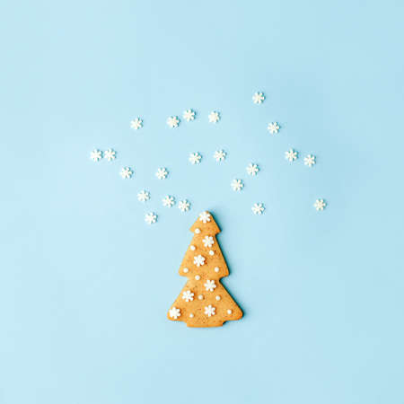 Happy New Year's Christmas card - traditional tree from ginger biscuits glazed sugar icing decoration on blue background, minimal stylish seasonal winter holiday card, banner, flyer, coupon invitationの写真素材