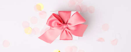 Gift or present box multicolored confetti on white table top view. Flat lay composition for...