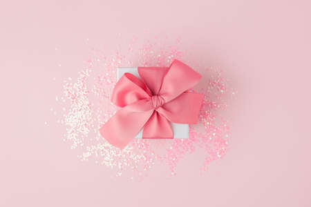Gift or present box and stars confetti on pink table top view. Flat lay composition for birthday, mother day, valentine or wedding. Stylish luxury monochrome concept, sale shopping flyerの写真素材