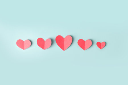 Paper hearts over the blue pastel background. Abstract background with paper cut shapes. Sainte Valentine, mother's day, birthday wedding greeting cards, invitation, celebration conceptの写真素材