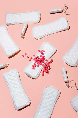 Girl, women intimate hygiene products - sanitary pads with blood, daily pads and tampon on pink...
