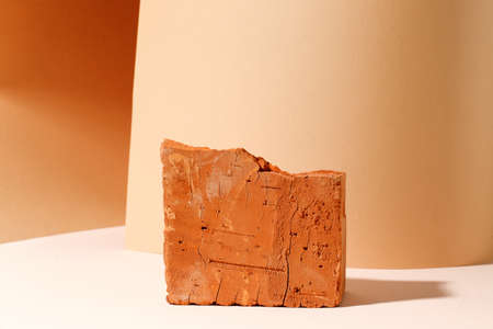 Beige bright brick podium tile on a beige background, natural background with hard shadow for your...
