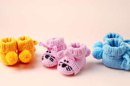 Set three Pairs of baby booties, shoes on pastel, cozy conceptual idea. Guess gender of the child,...
