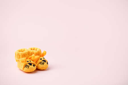 Pair of small baby socks with funny bunny rabbit decor on pink background with copy space for your warm message, baby shower, first newborn party background, copy spaceの写真素材