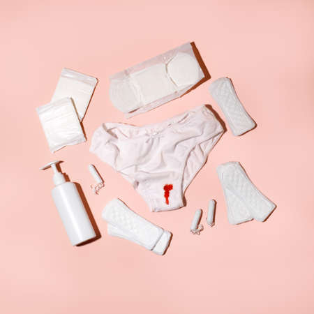 White cotton panties for women with traces of fresh red blood and care products. Concept of menstruation, female shame, taboo, daily hygiene, critical days, premenstrual syndromeの写真素材