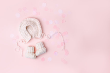 Pink knitted bonnet and booties socks. Set of baby clothes and accessories for spring, winter or summer. Fashion childs outfit, first baby girl wardrobe, baby shower. Flat lay, top view, copy spaceの写真素材