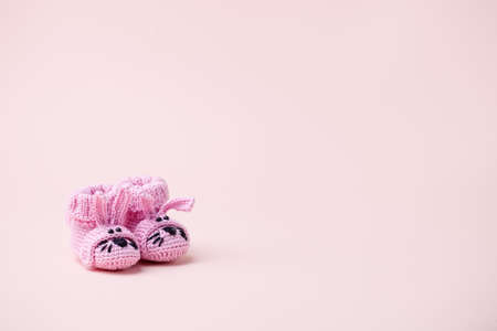 Pair of small baby socks with funny bunny rabbit decor on pink background with copy space for your warm message, baby shower, first newborn party background, copy spaceの写真素材