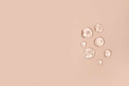 Pipette serum bottle dose of fluid hyaluronic acid with gel drops on neutral beige background....