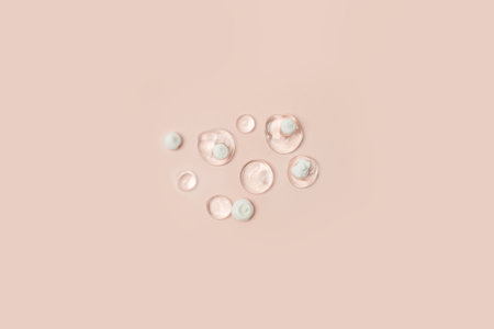 Lotion transparent gel drops texture background, Close-up drops transparent cosmetic aloe vera gel on neutral beige background with copy space. Body care and skin care, moistirize, abstractの写真素材