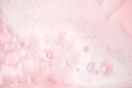 White foam bubbles texture on pink pastel background, copy space, banner for loundry, cleaning service, bathroom concept, clean, wash - liquid soap, shower gel, shampooの写真素材