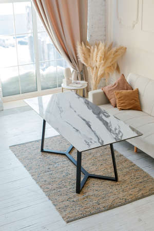 Comfortable modern interior design concept. Sofa, dinnng table with trendy decorations dry pampas...
