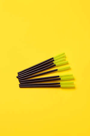 Black green makeup brushes, eyelash combs and eyebrows on trendy bright yellow background with copy space, banner, flyer coupon for lashmakers salon, beutician industryの写真素材