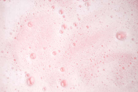 White foam bubbles texture on pink pastel background, copy space, banner for loundry, cleaning...