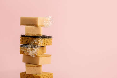 Set of beige color household sponges on pale pink background, concept of cleaning service, annual spring cleaning, disinfection, house cleaning, copy space, banner for advertising or siteの写真素材