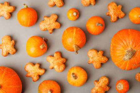 Pumpkin Spice cookies and Fall Decor from fresh orange pumpkins on gray background. Traditional Coffee Drink for Autumn Holidays, seasonal menu flyer, banner, thanksgiving themeの写真素材