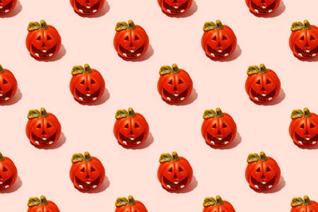 Ceramic jack-o-lantern candlestick on pink. Seamless pattern. Halloween concept, hard shadow, banner, printshop, flyer for seasonal party with copy spaceの写真素材