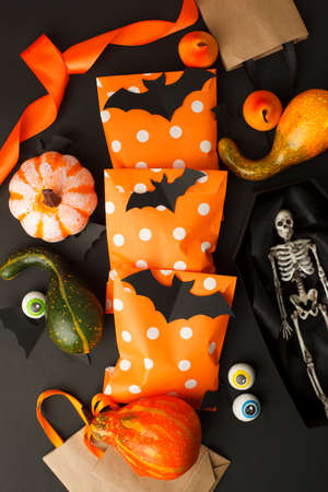 Happy Halloween holiday concept. Creative idea decoration of traditional candy bags on black background. Halloween party greeting card, invitation, banner, flyer, promotionの写真素材