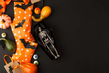 Happy Halloween holiday concept. Decorative skeleton of man in paper handmade coffin and traditional...