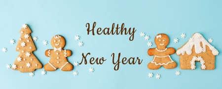 Healthy New Year's Christmas set of ginger biscuits - man, house, tree glazed sugar icing decoration on blue background, minimal seasonal winter holiday card.の写真素材