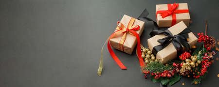 Christmas background with decorations and gift boxes on the black board, frame, copy space, Stylish...